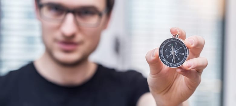 Young freelancer with compass holding in hand