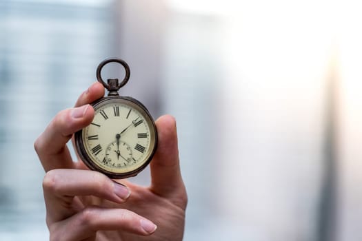 Time goes by: Man is holding a vintage watch in his hand, business context, copy space