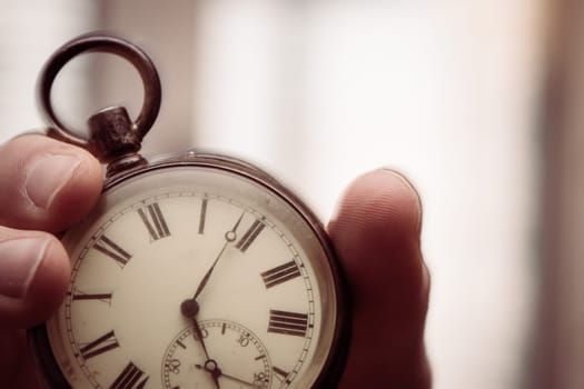 Time goes by: Man is holding a vintage watch in his hand, business context, copy space