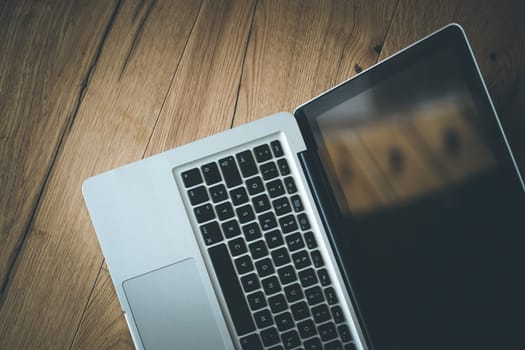 Close up of a laptop keyboard on a rustic wooden desk
