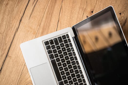 Close up of a laptop keyboard on a rustic wooden desk