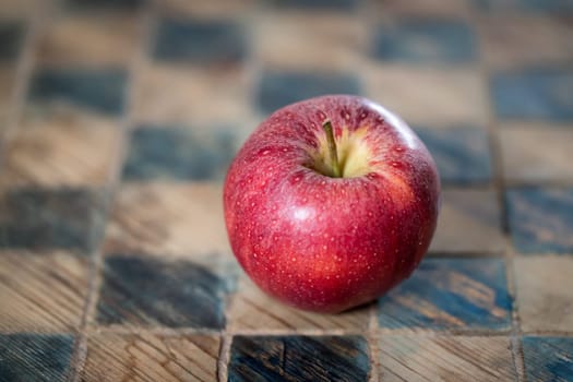 Close up of a red apple on a checked board