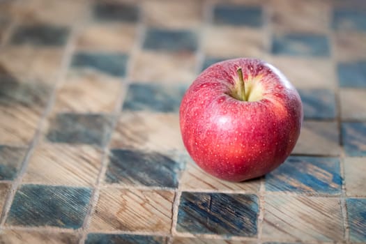 Close up of a red apple on a checked board