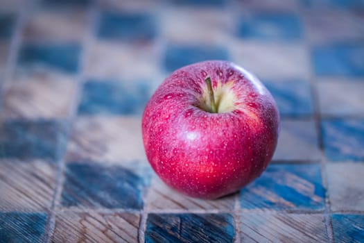 Close up of a red apple on a checked board