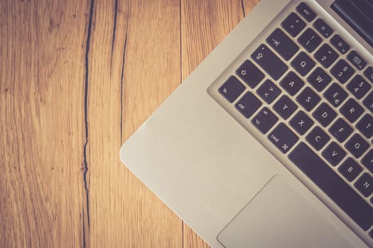 Close up of a laptop keyboard on a rustic wooden desk