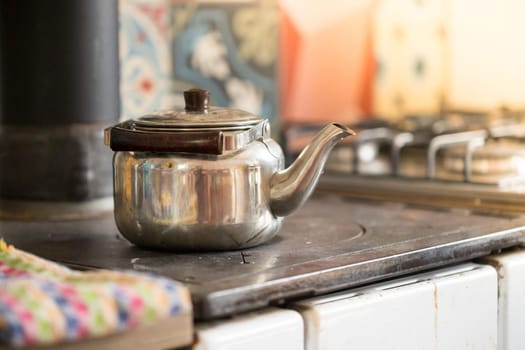 Metal tea cooker on a rustic old oven
