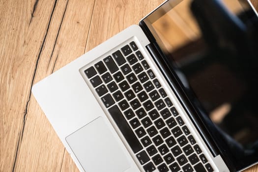 Close up of a laptop keyboard on a rustic wooden desk