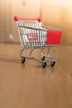 Online-Shopping and parcel service concept: Miniature shopping cart and cardboard boxes