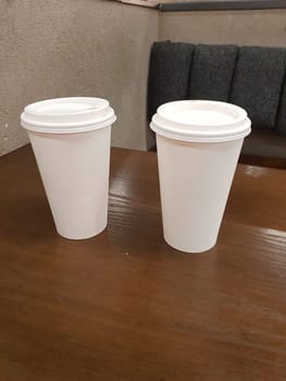 Side view of empty disposable takeaway coffee cup on a table