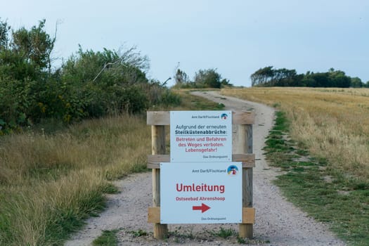 White warning sign with inscription in German - beware of cliffs on the Baltic Sea on the Darss