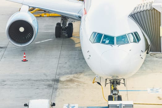 Modern passanger jet parked at runway in airport. Air travel and airplanes.