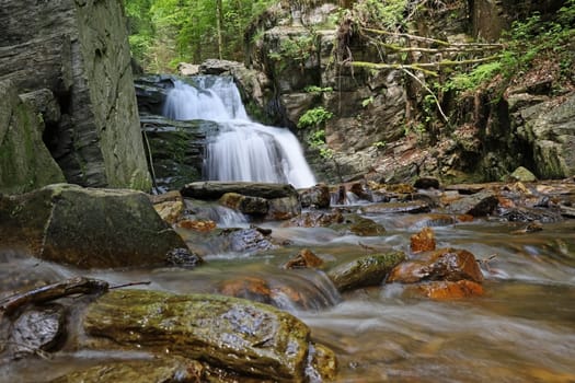 Beautiful waterfall in the middle of the forest. Silky effect of running water.