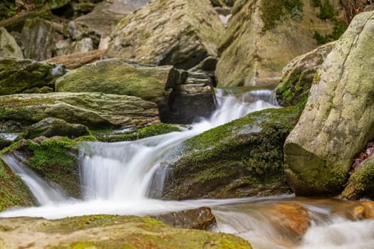 Silky effect of cascades of running water in a brook. Your object can be placed on a stone in the foreground.