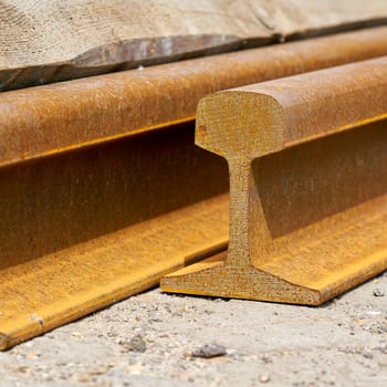Close up of the cross section of a rusty railroad rail in a storage yard