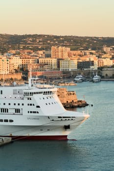 Civitavecchia. Italy - February 07, 2025: The ferry Splendid moored in Civitavecchia s harbor near an ancient stone fortress. A scene of modern naval transport against a historic coastal landscape. Concept: travel, tourism, and naval industry