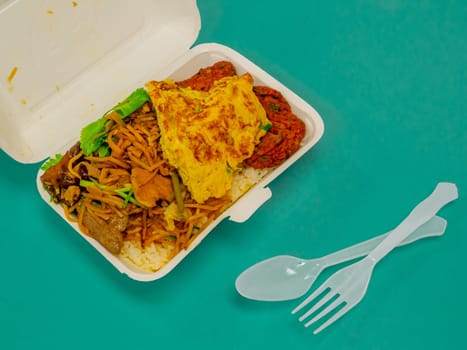 Thai food, stir fried crispy pork basil in foam box.