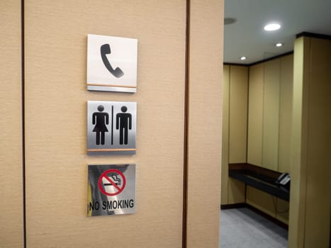 Men and women modern toilet signs on a green wall.