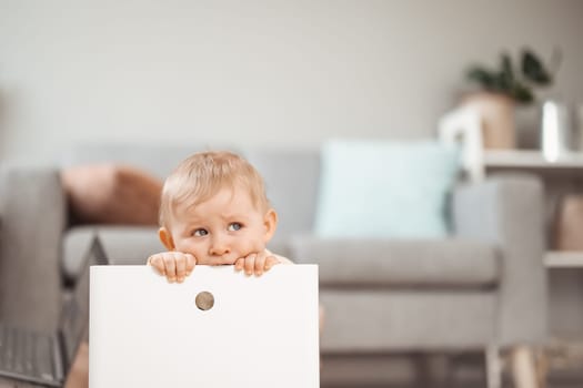 Cute boy sitting in the white plastic box. Tired child. Concept of the family and mother's love.