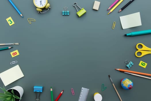 Back to school conceptual flat lay with different office supply objects and copy space area for text. Concept for primary and secondary school pupil on green background. Alarm clock, eraser, ruler