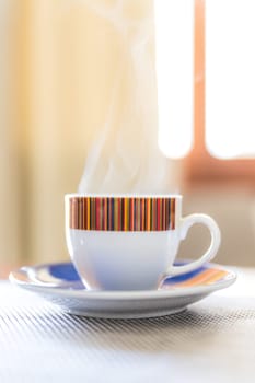 Cute little cup of italian espresso served in the morning, steaming