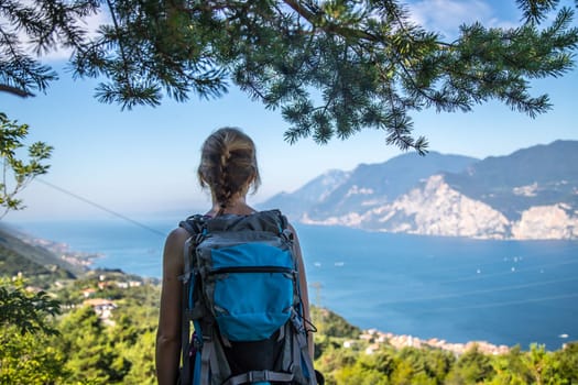 Young girl stands happily on Monte Baldo and enjoys the view. Hiking in Italy.