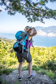 Young girl stands happily on Monte Baldo and enjoys the view. Hiking in Italy.