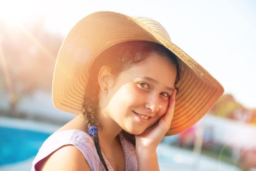 Sweet young girl posing with hat outdoors at sunset