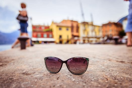 Italian harbour scene: Sunglasses on the stony ground
