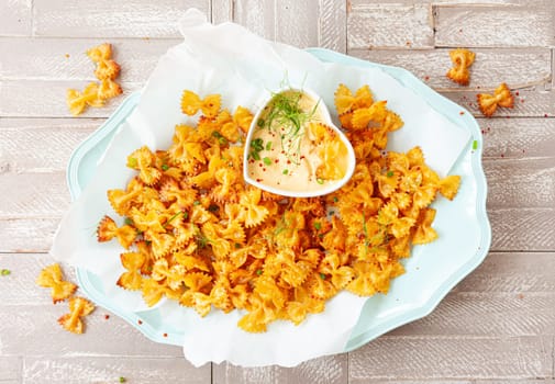 Spicy farfalle pasta chips with homemade herb dip