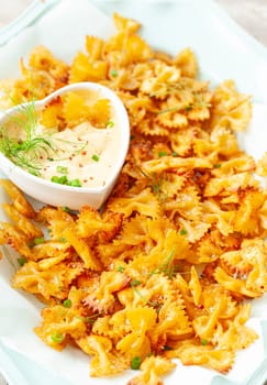 Spicy farfalle pasta chips with homemade herb dip