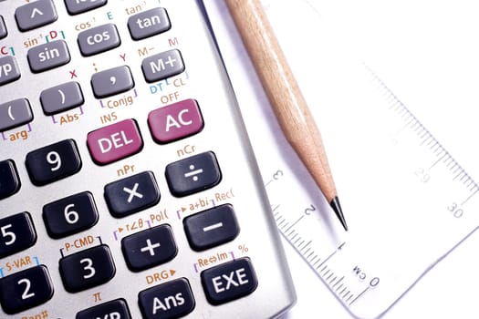 close-up of ruler,calculator,and pencil,focus on pencil-tip.