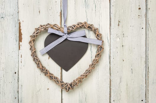 Heart with chalkboard in front of white wooden boards