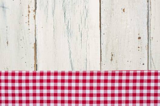 Red checkered tablecloth in front of a white wooden background