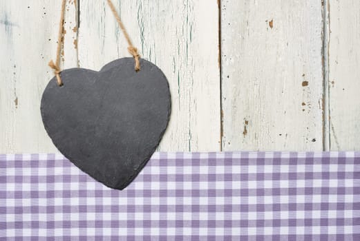 Empty heart board in front of white wooden boards