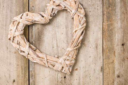 Braided heart in front of rustic wooden boards