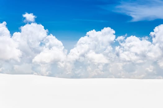 Snow covered mountain landscape with blue sky and fluffy cloud