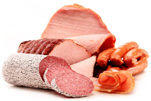 Assorted meat products including ham and sausages isolated on white