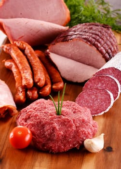 Assorted meat products including ham and sausages.