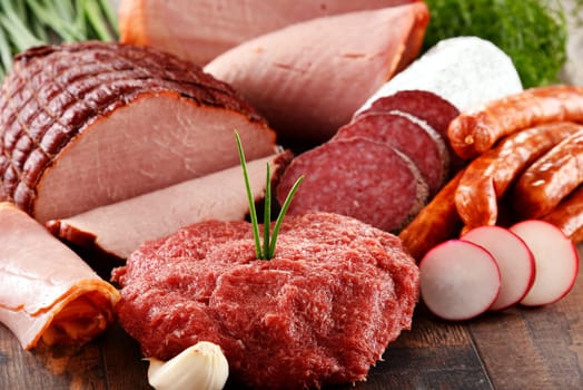 Assorted meat products including ham and sausages.