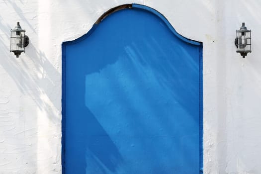 Old metal blue gateway with white wall