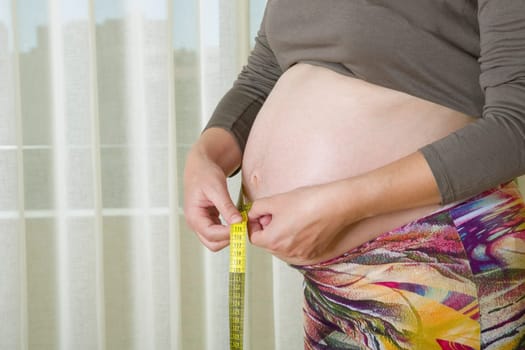 Closeup of pregnant woman at home