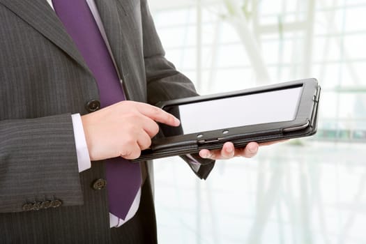 businessman using touch pad, close up shot on tablet pc, at the office