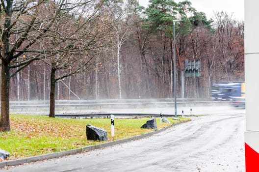 View from a parking lot to a highway in heavy rain.