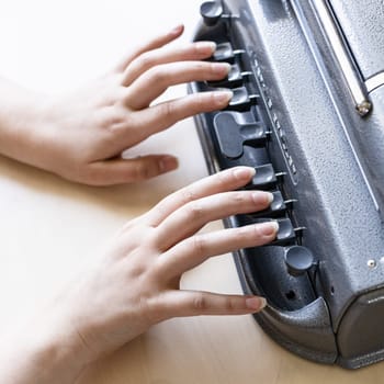 Moscow, Russia - June 5, 2021: fingers on keys of Perkins Brailler braille typewriter . The first Perkins Brailler was produced in 1951 by David Abraham, teacher at the Perkins School for the Blind