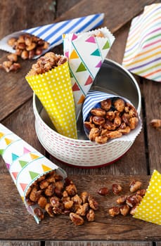 Sugar roasted almonds with cinnamon in little colorful paper bags