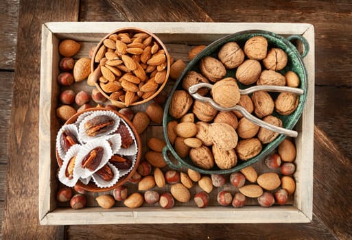 Selection of nuts and dates in rustic wooden tray