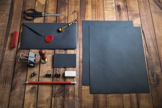 Set of black stationery elements on vintage wooden background. Photo of blank retro stationery. Responsive design mockup.