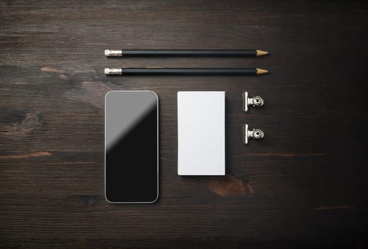 Smartphone, business card and pencils. Blank stationery set on wooden background. ID template. Mockup for branding identity for designers. Top view. Flat lay.