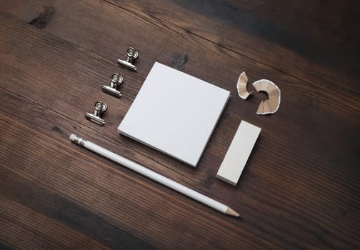 Photo of blank stationery set. Blank notes, pencil and eraser on wooden background.