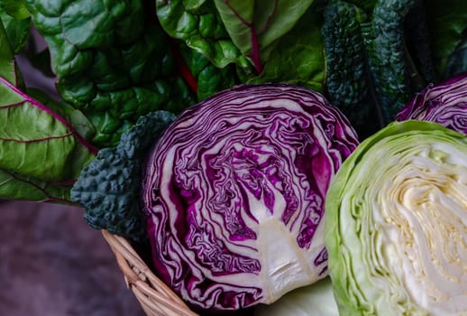 Fresh leaves of Italian kale and Swiss chard, green and purple cabbages in a basket. Superfood , healthy and diet concept